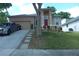 Charming home featuring a manicured lawn, inviting red front door, and lovely landscaping at 908 Hilly Bend Dr, Apopka, FL 32712