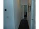 Hallway with dark wood floors leading to bedroom, showing neutral wall paint and decor at 908 Hilly Bend Dr, Apopka, FL 32712