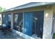 View of the screened porch featuring blue curtains, outdoor furniture, and a grill at 908 Hilly Bend Dr, Apopka, FL 32712