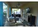 The bright screened porch offers a cozy lounge area with comfortable seating and a TV at 908 Hilly Bend Dr, Apopka, FL 32712