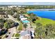Aerial view showcasing a waterfront community with a pool, tennis court, and scenic lake views at 9385 Lake Lotta Cir, Gotha, FL 34734