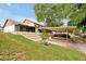 Exterior view of backyard featuring carport, and terraced landscaping leading up to a screened porch at 9385 Lake Lotta Cir, Gotha, FL 34734