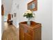 Bright hallway featuring wood-look flooring, a decorative console table with flowers, and stylish wall decor at 9385 Lake Lotta Cir, Gotha, FL 34734