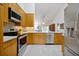 Well-lit kitchen featuring stainless steel appliances, light wood cabinets, and neutral countertops at 9385 Lake Lotta Cir, Gotha, FL 34734