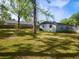 Large grassy backyard with trees and an outbuilding at 1011 Beulah Dr, Edgewater, FL 32132