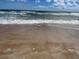 A peaceful beach scene with gentle waves and a white bird at 1011 Beulah Dr, Edgewater, FL 32132