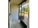 Enclosed front porch featuring a screened door and tile flooring at 1011 Beulah Dr, Edgewater, FL 32132