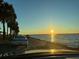 A scenic view of the water with palm trees and a sunset sky from the car at 1011 Beulah Dr, Edgewater, FL 32132