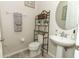 Elegant bathroom with a pedestal sink, decorative shelving, and tasteful decor at 1011 Cedar Bay Ln, Winter Springs, FL 32708