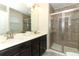 Well-lit bathroom features a double sink vanity and glass enclosed shower with tile surround at 1011 Cedar Bay Ln, Winter Springs, FL 32708