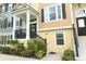 Inviting townhouse entrance with well-maintained landscaping, a cozy porch, and elegant black railings at 1011 Cedar Bay Ln, Winter Springs, FL 32708