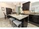 Modern kitchen featuring an island with seating, stainless steel appliances and dark cabinetry at 1011 Cedar Bay Ln, Winter Springs, FL 32708