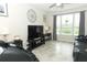 Comfortable living room with large windows, tile flooring, and a large TV for entertaining guests at 1011 Cedar Bay Ln, Winter Springs, FL 32708