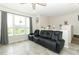 Cozy living room with large windows, tile flooring, and a comfortable reclining sofa for relaxation at 1011 Cedar Bay Ln, Winter Springs, FL 32708