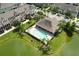 Aerial view of a community pool with ample seating and landscaping near the pond at 1011 Cedar Bay Ln, Winter Springs, FL 32708