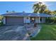 Charming single-story home featuring a gray facade, well-maintained lawn, and an attached two-car garage at 1019 Chippewa Trl, Daytona Beach, FL 32117