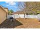 Backyard featuring a grill, white privacy fence, and mature trees at 10321 Pebblestone Ct, Leesburg, FL 34788