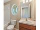 A bathroom with a vanity, toilet, and a decorative stained glass window above the bathtub at 10321 Pebblestone Ct, Leesburg, FL 34788