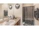 A bathroom featuring a single sink vanity and a shower-tub combo with a decorative curtain at 10321 Pebblestone Ct, Leesburg, FL 34788