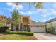 Charming two-story home with a well-manicured lawn, stone accents, and a two-car garage at 10321 Pebblestone Ct, Leesburg, FL 34788
