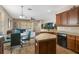 Open kitchen with wood cabinets, black appliances, and an island flowing into a cozy living space at 10321 Pebblestone Ct, Leesburg, FL 34788