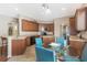Bright kitchen features wood cabinets, black appliances, and a glass-top dining table with vibrant blue chairs at 10321 Pebblestone Ct, Leesburg, FL 34788
