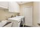 Bright laundry room features modern appliances, upper cabinets, and a convenient utility sink at 10321 Pebblestone Ct, Leesburg, FL 34788