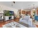 Spacious living room with wood floors, a television, and a view of the dining area and kitchen at 10321 Pebblestone Ct, Leesburg, FL 34788