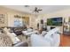 Open living room with a large leather sofa, shag rug, and sliding glass doors to the backyard at 10321 Pebblestone Ct, Leesburg, FL 34788