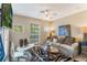 Inviting living room features neutral decor, a comfortable sofa, and multiple windows for natural light at 10321 Pebblestone Ct, Leesburg, FL 34788