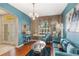 Living room featuring hardwood floors, blue walls, modern furniture, and a decorative chandelier at 10321 Pebblestone Ct, Leesburg, FL 34788