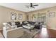 Comfortable living room with a large leather sectional, plush rug, and view of the screened patio at 10321 Pebblestone Ct, Leesburg, FL 34788