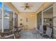 Relaxing screened patio with comfortable seating, ceiling fan, and sliding glass doors at 10321 Pebblestone Ct, Leesburg, FL 34788