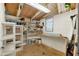 Basement storage room with exposed beams, a small window, and open shelving for storage and organization at 1179 Seminole St, Clermont, FL 34711