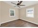 Bedroom featuring dark wood floors and two windows at 1179 Seminole St, Clermont, FL 34711
