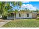 Charming single-story home featuring a screened porch and well-maintained front yard with mature trees at 1179 Seminole St, Clermont, FL 34711
