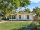 Inviting single-story home with a screened porch, landscaped front yard, and mature trees at 1179 Seminole St, Clermont, FL 34711