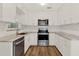 Modern kitchen featuring stainless steel appliances, granite countertops, and white cabinetry at 1179 Seminole St, Clermont, FL 34711