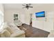 Bright living room featuring hardwood floors, a ceiling fan, and a built-in shelving unit at 1179 Seminole St, Clermont, FL 34711