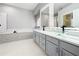 Bright bathroom featuring glass vessel sinks, modern vanity, and a separate tub and shower at 1213 Brampton Pl, Lake Mary, FL 32746