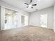 Large main bedroom featuring neutral carpet, ceiling fan, and doors to screened patio at 1213 Brampton Pl, Lake Mary, FL 32746