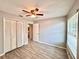 This bedroom features wood-look tile flooring, ceiling fan, closet, and mini blinds at 1232 Roma Ct, Orlando, FL 32825
