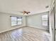 Serene bedroom with wood-look tile floors, neutral gray walls, ceiling fan, and ample natural light at 1232 Roma Ct, Orlando, FL 32825
