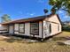 Well-kept single-story house featuring white siding, brown trim, and a neat lawn with young plants at 1232 Roma Ct, Orlando, FL 32825
