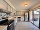 Modern kitchen features stainless steel appliances, gray cabinetry, and sliding glass doors to a patio area at 1232 Roma Ct, Orlando, FL 32825