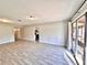 Open-concept living space with gray walls, wood-look tile floors and lots of natural light from sliding doors at 1232 Roma Ct, Orlando, FL 32825