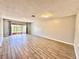 Bright, airy living room with modern wood-look tile floors and sliding glass doors leading to outdoor space at 1232 Roma Ct, Orlando, FL 32825