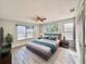 This spacious main bedroom features wood-look tile flooring, ceiling fan, and two large windows at 1232 Roma Ct, Orlando, FL 32825
