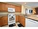 Bright kitchen features light wood cabinets, a white stove and microwave, and neutral countertops at 13427 Blue Heron Beach Dr # 1802, Orlando, FL 32821