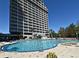 Resort-style pool with lounge chairs and a towering condo building offering multiple balconies at 13427 Blue Heron Beach Dr # 1802, Orlando, FL 32821